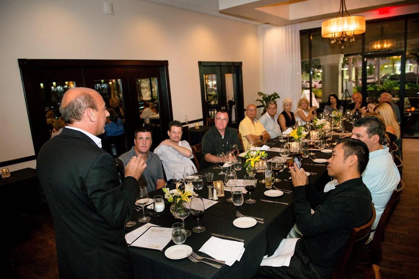 Host speaking to guests at private corporate dinner