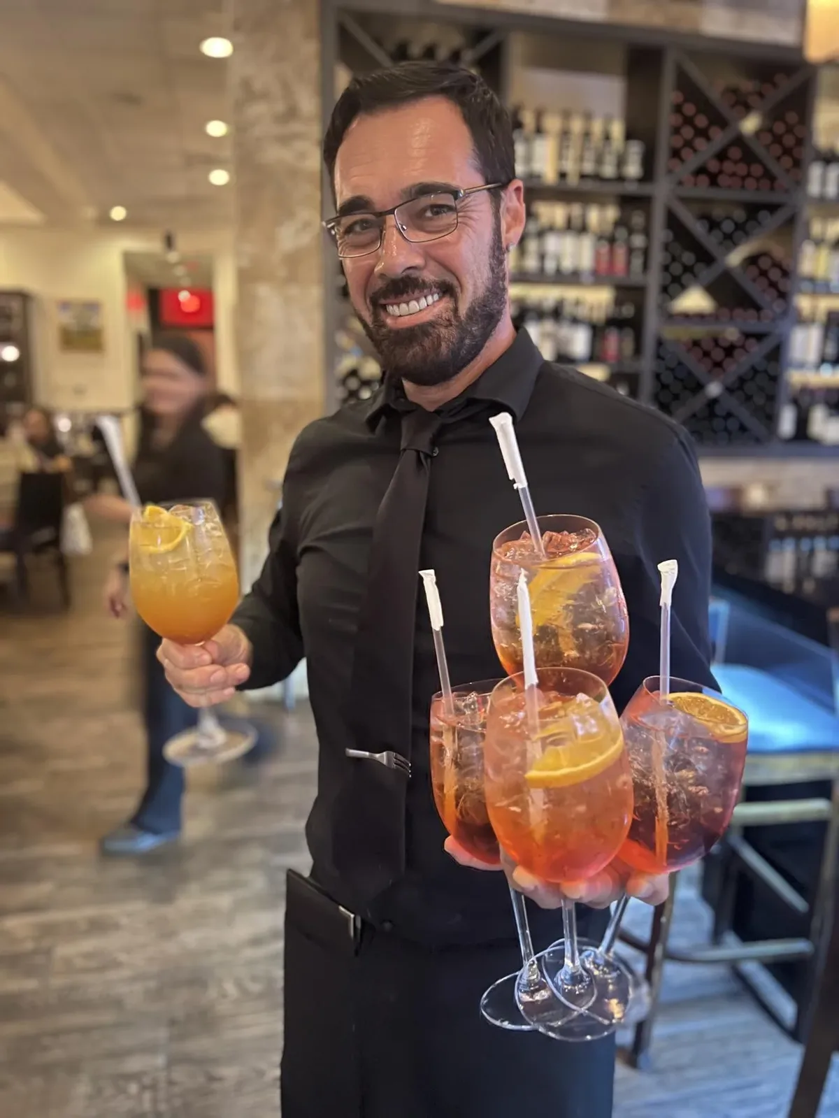 Server with Aperol Spritz cocktails at Vincenzo