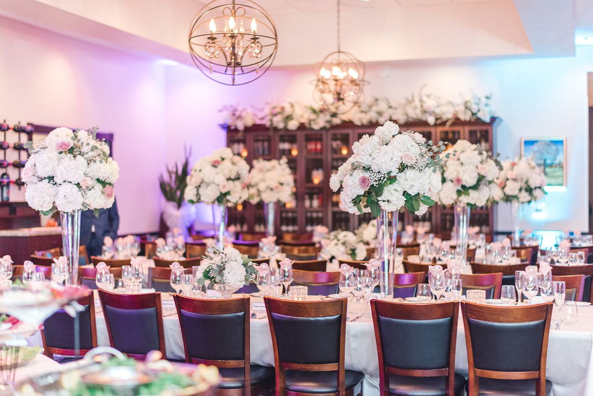 Wedding reception with white flowers and purple uplighting at Vincenzo